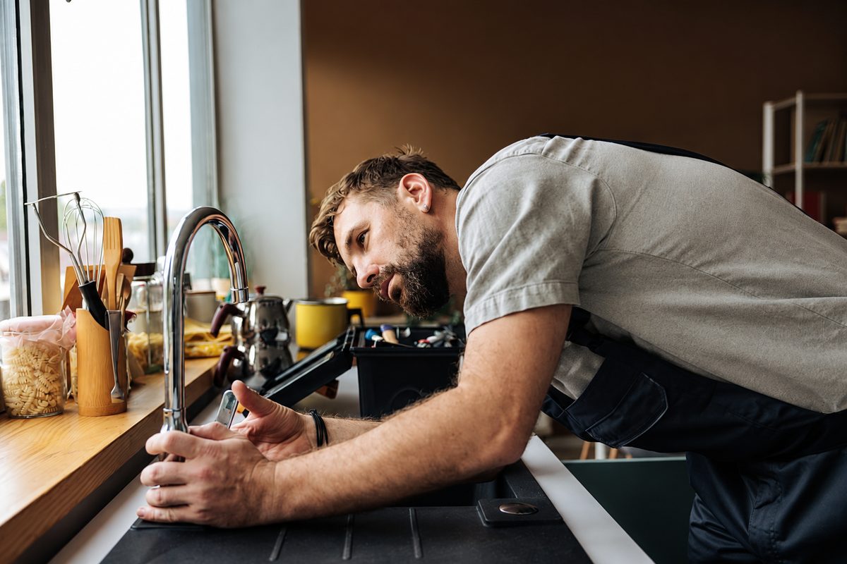Plumber fixing a kitchen tap